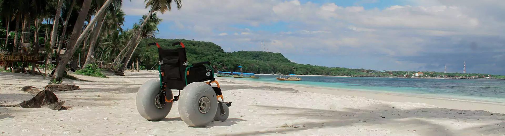 Rollstuhlreisen Sulawesi Rollstuhl am Strand Palmen